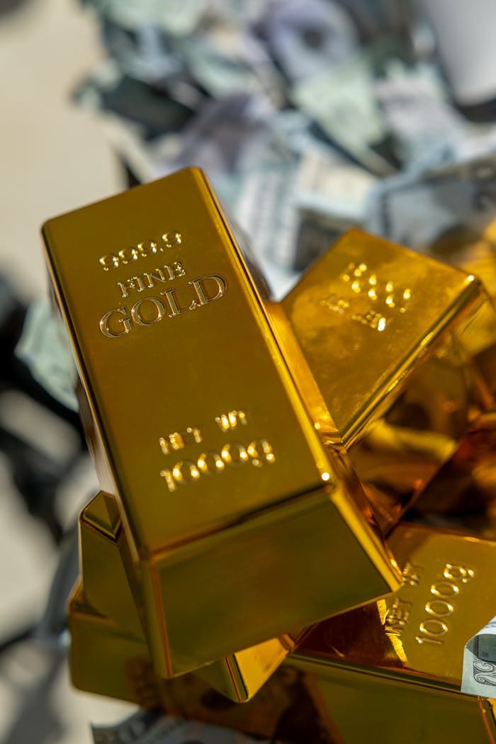 A close-up of shining gold bars on a pile of cash, symbolizing wealth and investment.